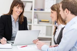 Young couple sitting in an office talking to a Estate lawyer